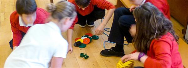 Pupils sorting through plastic parts to build a toy robot with.
