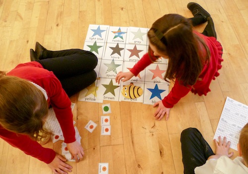 A photo of Primary schoolchildren building a Bee-Bot algorithm with cue cards.